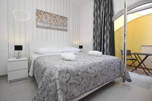 a bedroom with a bed with two towels on it at Apartments Zarok Beach Holiday in Baška