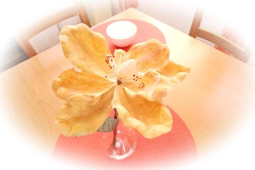 a vase with a flower sitting on a table at Apartments Zarok Beach Holiday in Baška