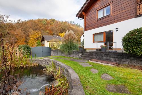 a house with a pond in the yard at Fewo Standfuss in Dausenau