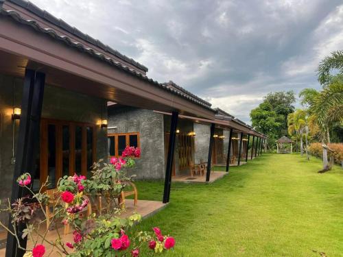 a row of houses with flowers in the yard at The Loft Baannaisuan in Chiang Rai