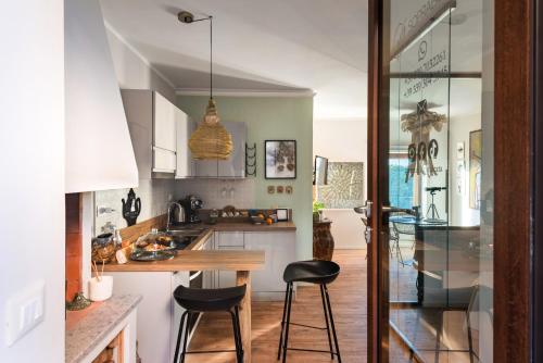 a kitchen with a table and two stools in it at SopraBosco Calcata Art & Design Apartment in Calcata