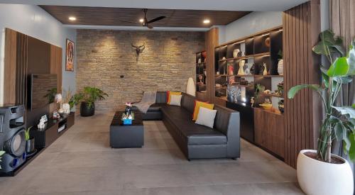 a living room with a couch and a brick wall at SaffronStays Earl Grey in Khandala