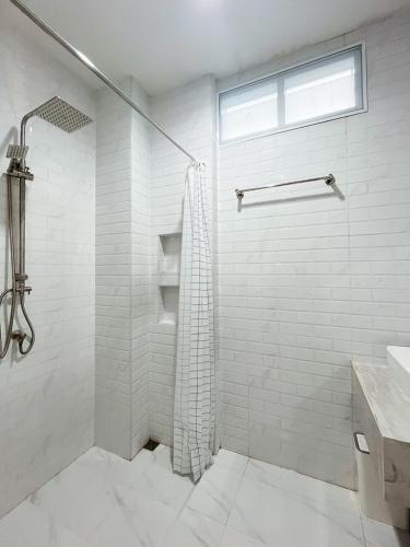 a white bathroom with a shower and a sink at Sleeping Shine de Budget พักได้ 2-3 ท่าน in Satun
