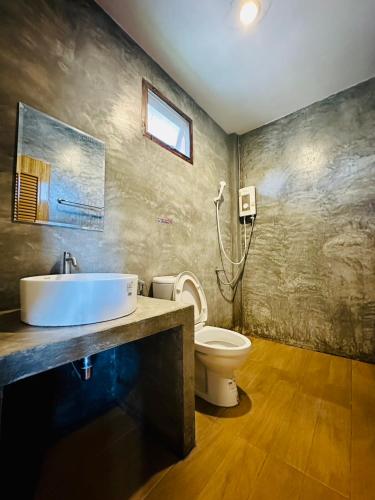 a bathroom with a sink and a toilet at The Loft Baannaisuan in Chiang Rai
