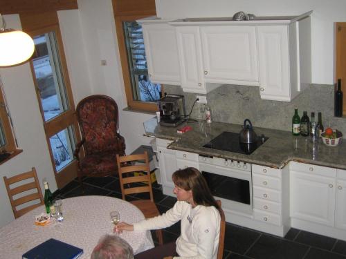 a woman sitting at a table in a kitchen at Senda 517 C in Scuol
