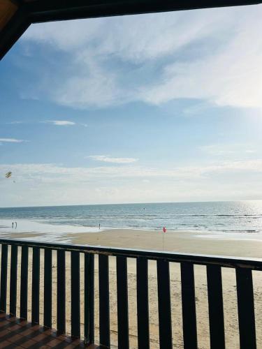 a view of a beach with a fence and the ocean at Eco Wooden Homes in Benaulim