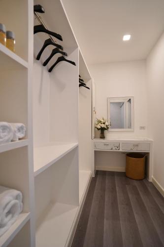 a dressing room with white shelves and a mirror at Tarn Villa Krabi in Krabi