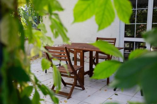 a wooden table and two chairs on a patio at Green Terrace 10min from TERMAL BATH in Komárom