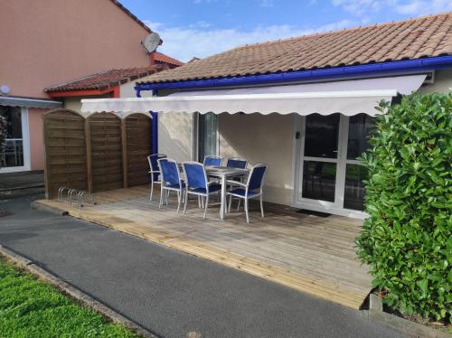 une terrasse en bois avec des chaises et une table. dans l'établissement Villa dans résidence de vacances avec piscine, tennis et aire de jeux, à Soustons