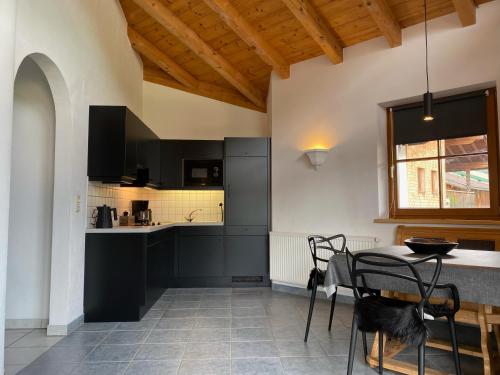 a kitchen with black cabinets and a table at Haus Albertha in Ehrwald