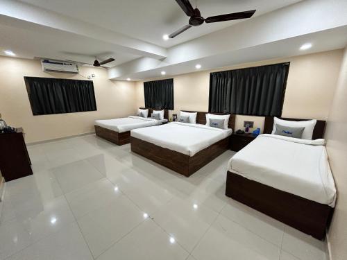 a room with three beds in a room at Hotel Pravasa stay ,Shirdi in Shirdi