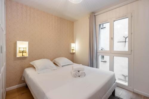une chambre avec un lit blanc avec une fenêtre dans l'établissement Le précieux de Raoul Nancy centre avec ascenseur, à Nancy