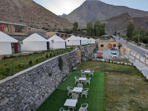 a group of tables and chairs on a green field at Apex Hotels and Resorts Hussaini in Hunza