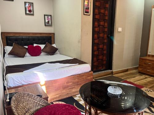 a bedroom with a bed and a table and chairs at Traditional Hotel & Restaurant !! Kurseong !! Best Hotel in Kurseong in Darjeeling