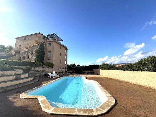 une piscine devant un immeuble dans l'établissement Appartement avec vue imprenable sur la mer, terrasse et piscine, à Propriano