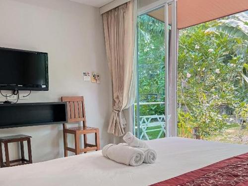 a bedroom with a bed and a large window at Naiyang Boutique Resort in Ban Phak Chit