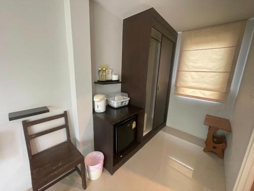une petite salle de bains avec une armoire noire et une chaise dans l'établissement Naiyang Boutique Resort, à Ban Phak Chit