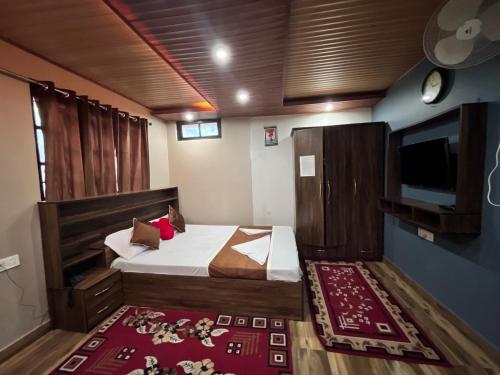 a bedroom with a bed and a flat screen tv at Traditional Hotel & Restaurant !! Kurseong !! Best Hotel in Kurseong in Darjeeling