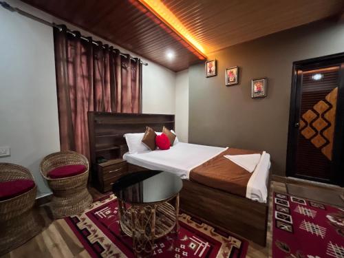 a room with a bed and two chairs in it at Traditional Hotel & Restaurant !! Kurseong !! Best Hotel in Kurseong in Darjeeling
