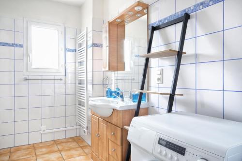 a bathroom with a sink and a washing machine at Le Poulpe Bleu - Maison 6p avec jardin in Saint-Jean-de-la-Rivière