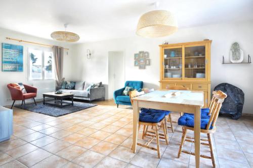 un salon avec une table et des chaises dans l'établissement Le Poulpe Bleu - Maison 6p avec jardin, à Saint-Jean-de-la-Rivière