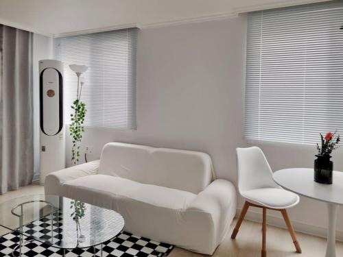 a living room with a white couch and a table at Stay Toseong in Busan