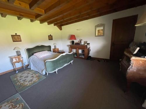 une chambre avec un lit et une table avec une lampe dans l'établissement Maison de famille entre lacs et montagnes, à Cusy