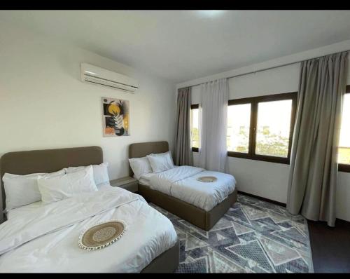 a hotel room with two beds and a window at كمبوند مفيدا in New cairo