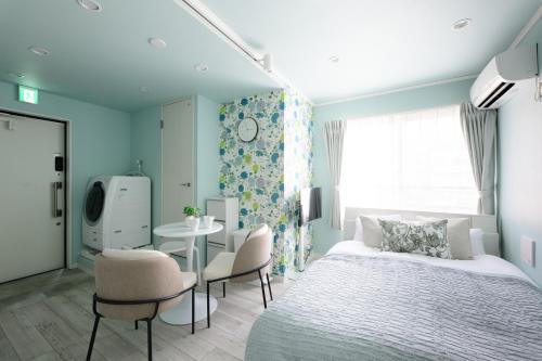 a bedroom with a bed and a table and chairs at スカイフィール大久保 in Tokyo