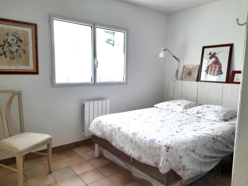 une chambre avec un lit, une chaise et une fenêtre dans l'établissement Maison 2 pièces 4 personnes proche de l'océan - GAELIG, à Sarzeau