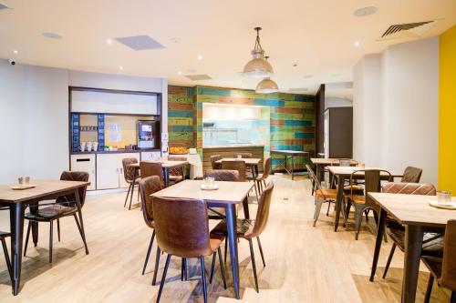 a restaurant with tables and chairs and a kitchen at Belvilla Newport City Centre Lifestyle in Newport