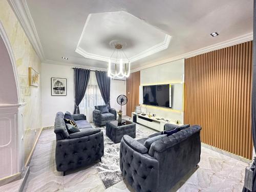 Una sala de estar con dos sofás y un televisor. en Hantrope Service Apartments, en Oba