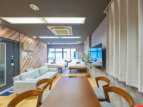 a room with couches and a table and chairs at Shimbashi Hotel Sho in Tokyo