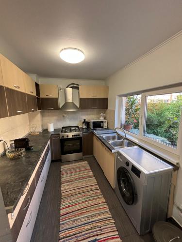a kitchen with a washer and a sink and a dishwasher at Charming two- bedroom house in Bucharest