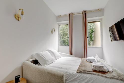 une chambre blanche avec un lit et une fenêtre dans l'établissement Bluestay 806 - Superb studio, à Paris