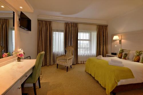a hotel room with a large bed and a bathroom at Val Du Charron Wine & Leisure Estate in Wellington