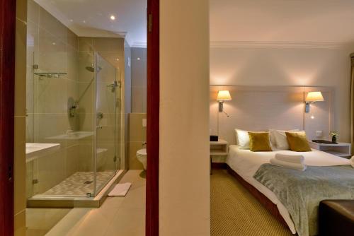 a hotel room with a bed and a shower at Val Du Charron Wine & Leisure Estate in Wellington