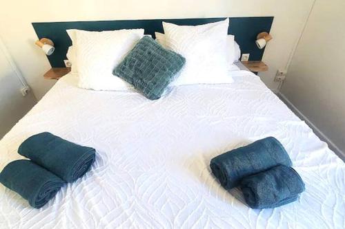 a large white bed with three pillows on it at Pépite citadine à St Pierre in Saint-Pierre