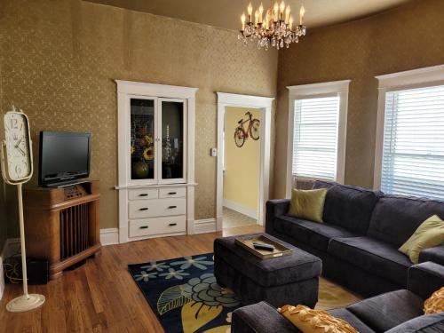 a living room with a couch and a tv at Vintage Parlor home in Grand Junction