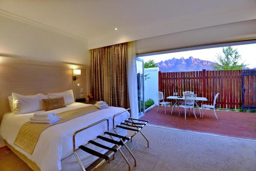 a bedroom with a bed and a balcony with a table at Val Du Charron Wine & Leisure Estate in Wellington