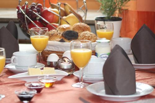 a table topped with plates and glasses of orange juice at Gasthof zur Post in Zwiefalten