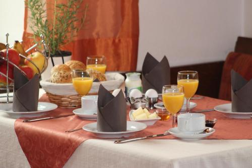 ein Tisch mit Essen und Gläsern Orangensaft in der Unterkunft Gasthof zur Post in Zwiefalten