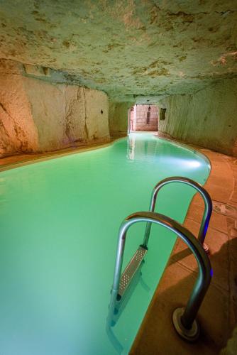 a large swimming pool in a cave with at Logis Demeure de la Vignole in Turquant