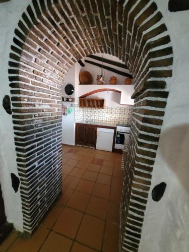 a kitchen with a brick archway in a kitchen at Complejo turístico El Soldado. in Villanueva del Duque