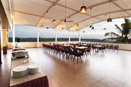 a dining room with tables and chairs in a building at Magnet Hotel in Kannur
