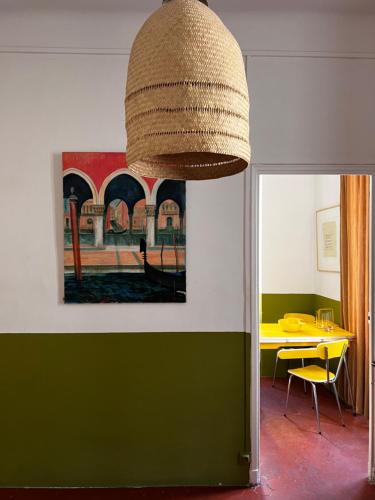 une chambre avec une table et une lampe à suspendre dans l'établissement L'appartement du Café de l'horloge, à La Ciotat