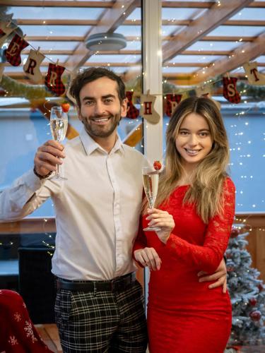 a man and a woman holding champagne glasses at Rajska polana Domki PREMIUM ,na odludziu z prywatną BALIĄ z jacuzzi i sauną ,Cisza,rowery elektryczne,góry,astroprzygoda,- Adršpach, Skalne Miasto, Zamek Książ,Andrzejówka,Karpacz, Śnieżka,Janskie Laznie,Pec in Mieroszów