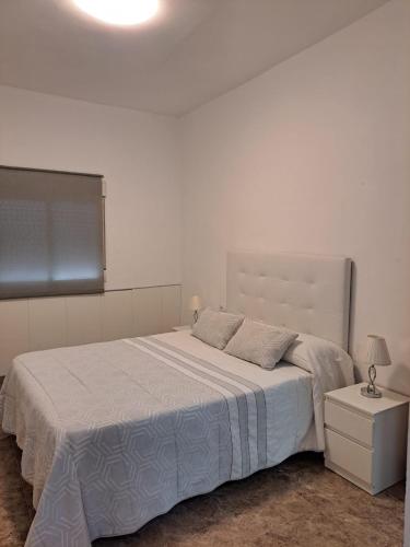 a bedroom with a large bed with a white bedspread at Apartamento con jacuzzi in Cartagena