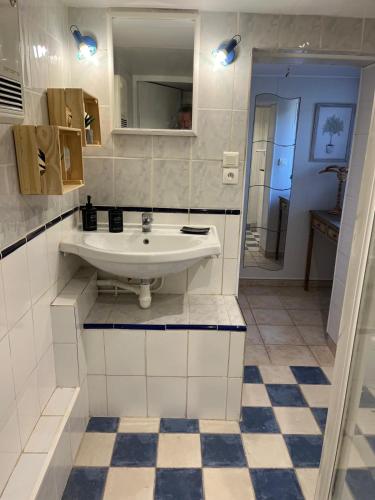 une salle de bain blanche avec un lavabo et un miroir dans l'établissement Chambre avec terrasse, à Fréjus