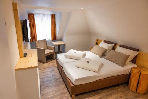 a bedroom with a bed with white sheets and pillows at Gasthof zum Ochsen in Vöhrenbach